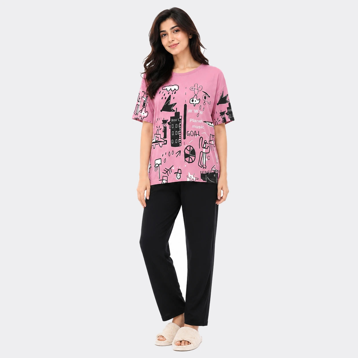 Woman wearing a pink graphic t-shirt and black pants on a white background