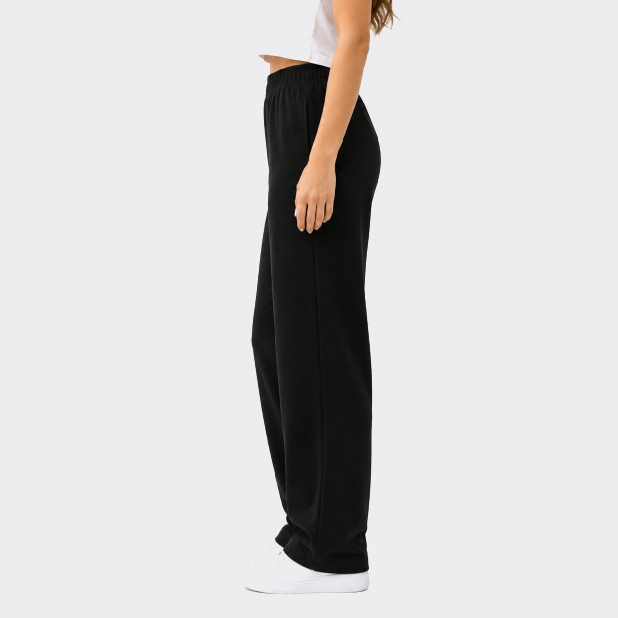 Person wearing black wide-leg pants on a white background
