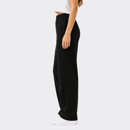 Person wearing black wide-leg pants on a white background