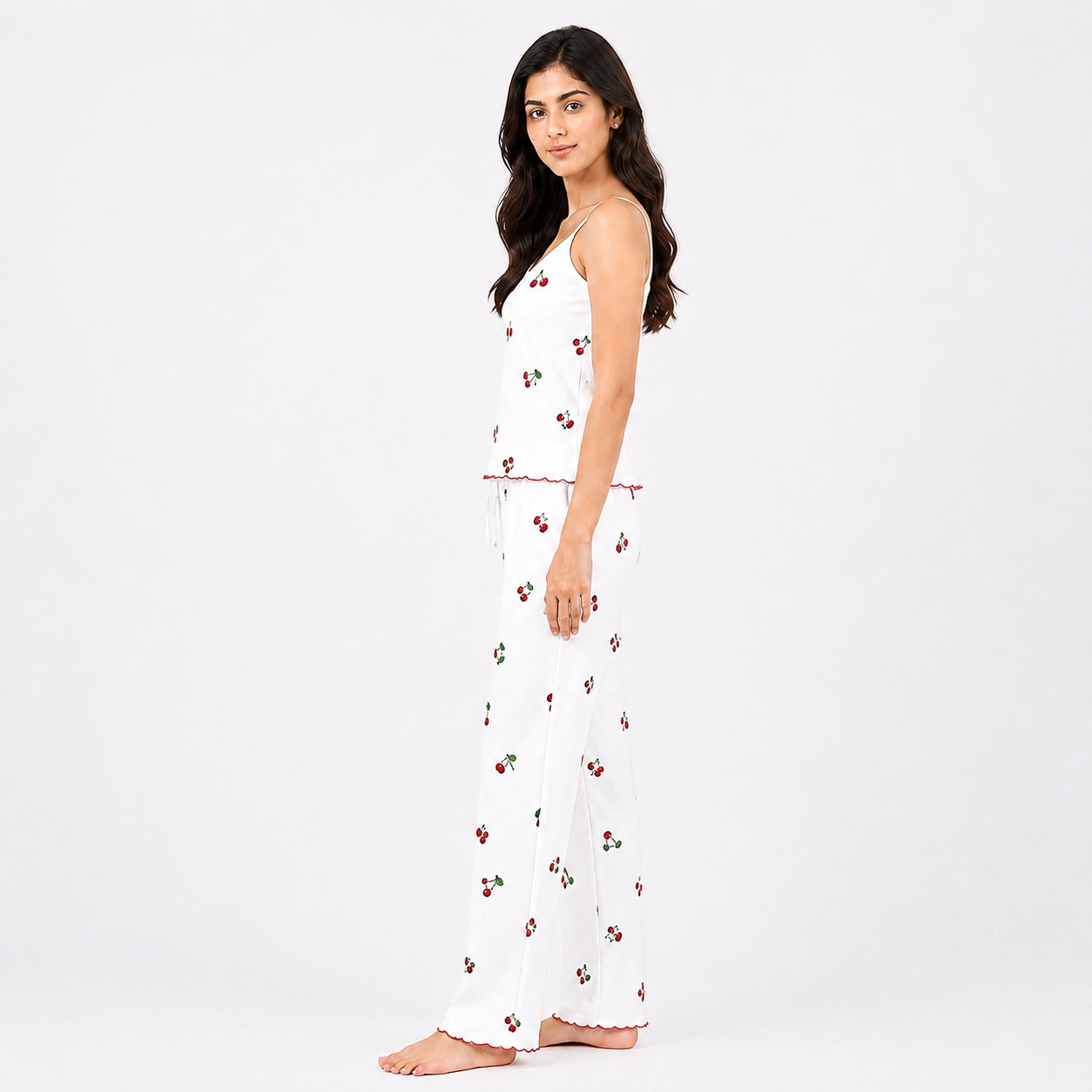 Woman wearing a white dress with red floral patterns on a white background